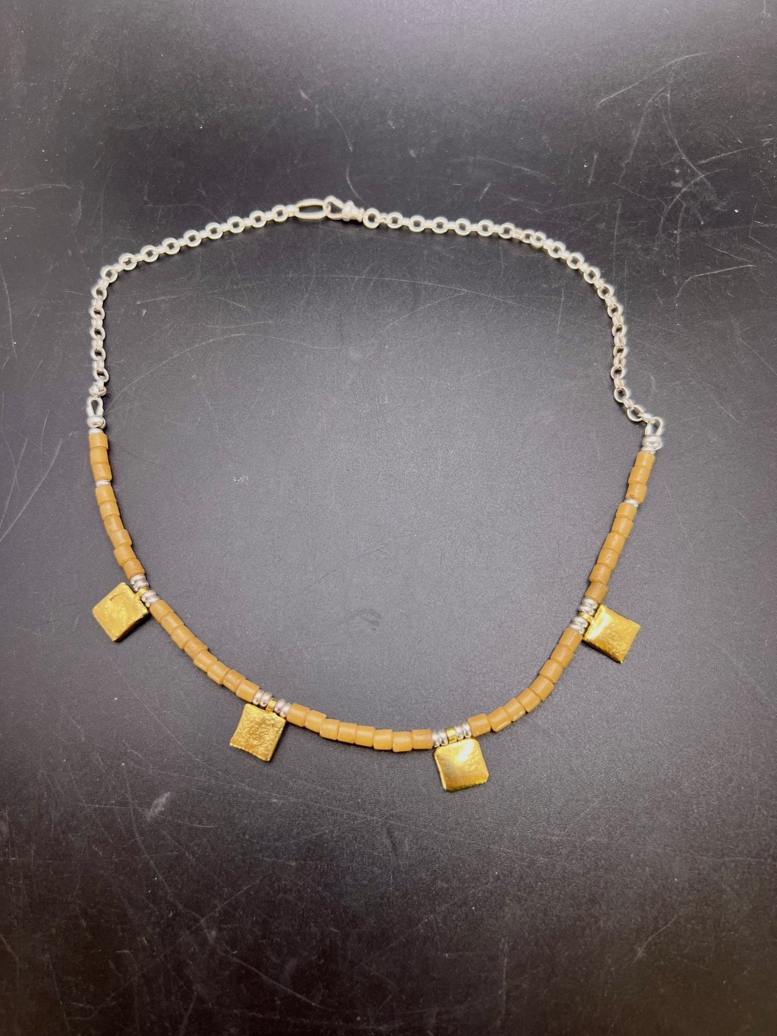 Tan tiles and gold necklace