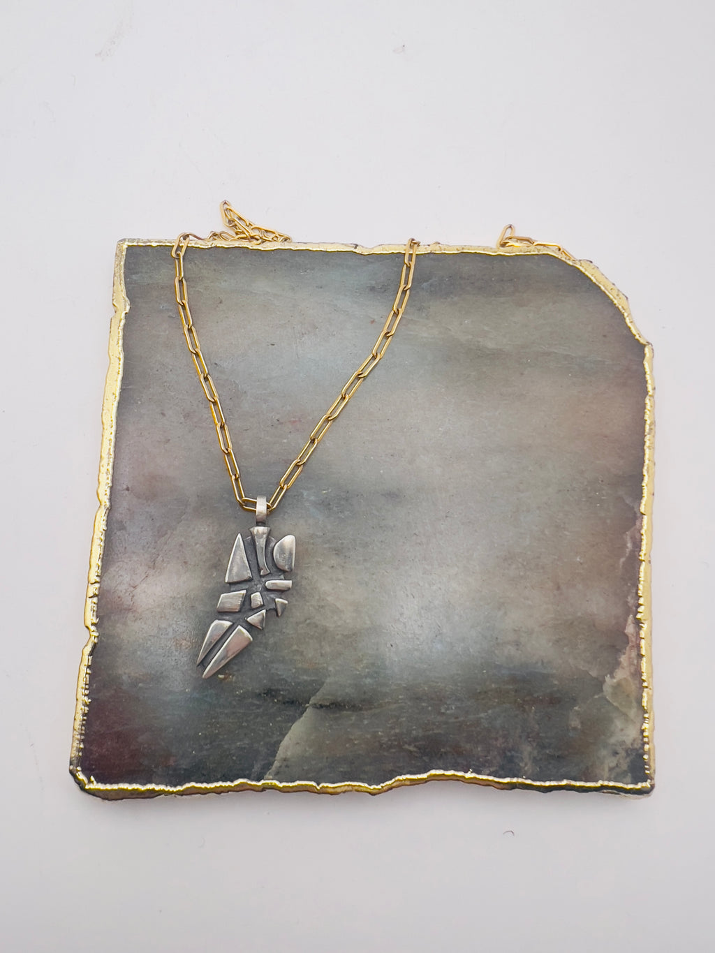Parched earth pendant on gold chain