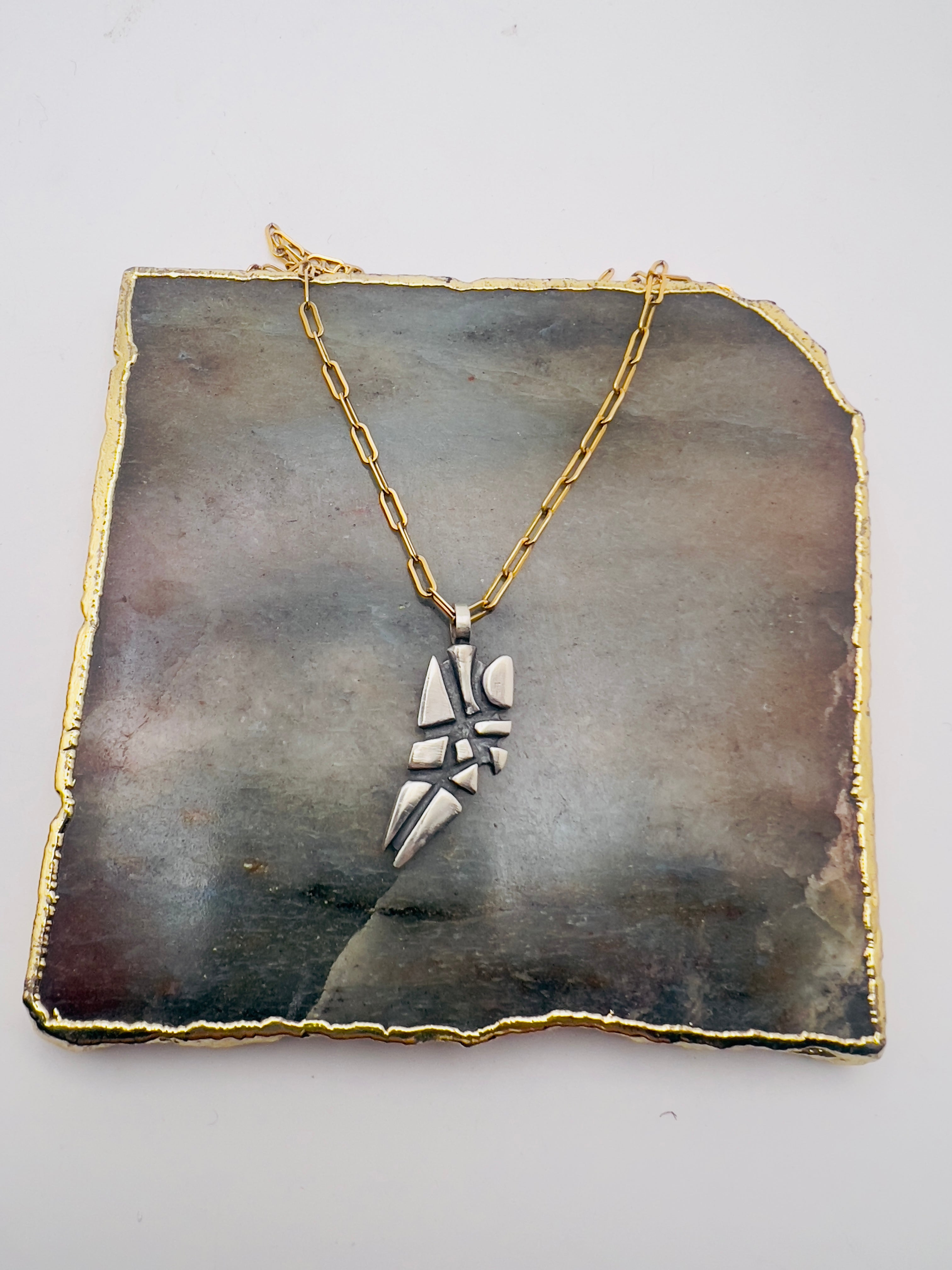 Parched earth pendant on gold chain
