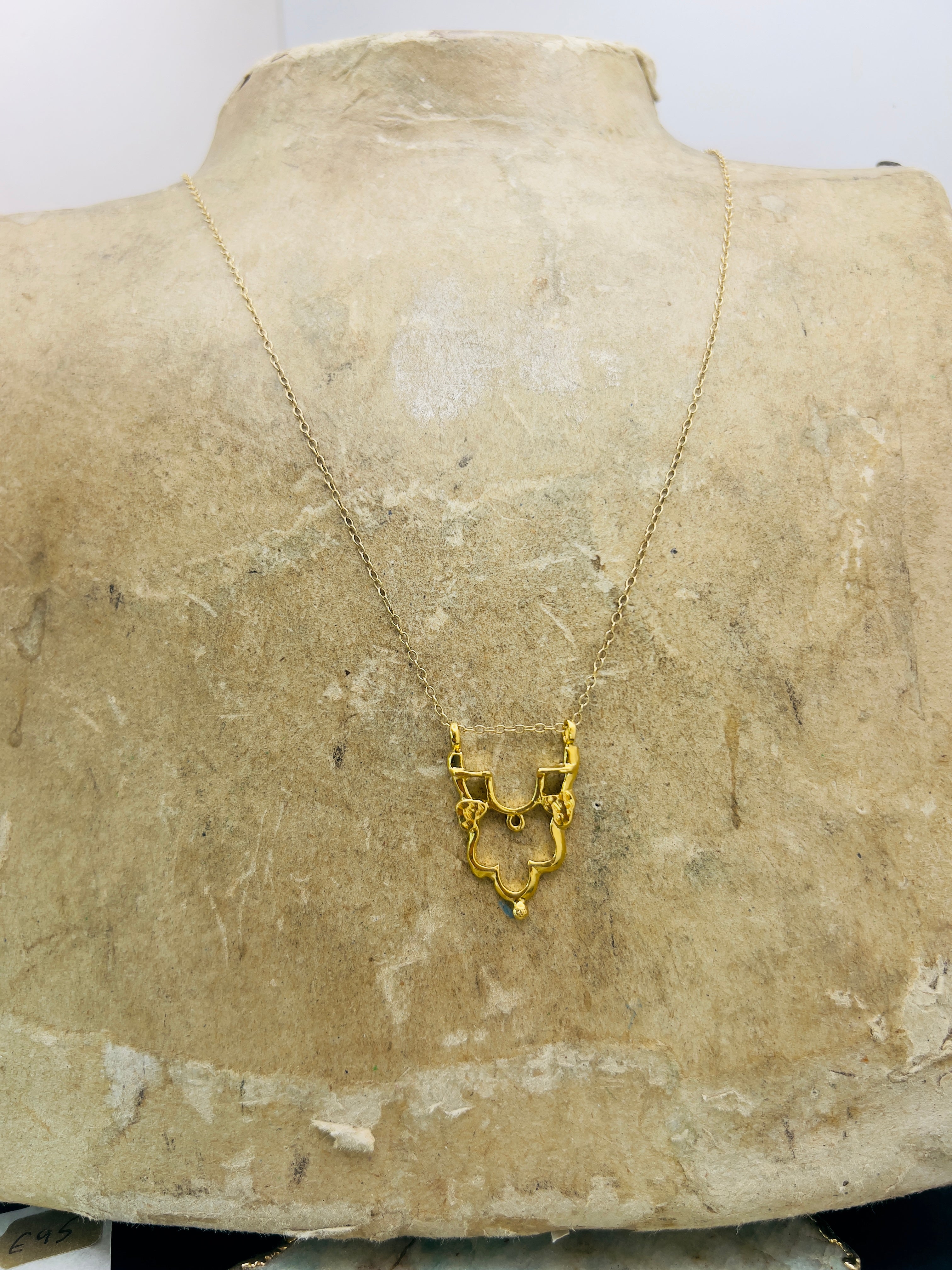 Gold Shikara half pendant.