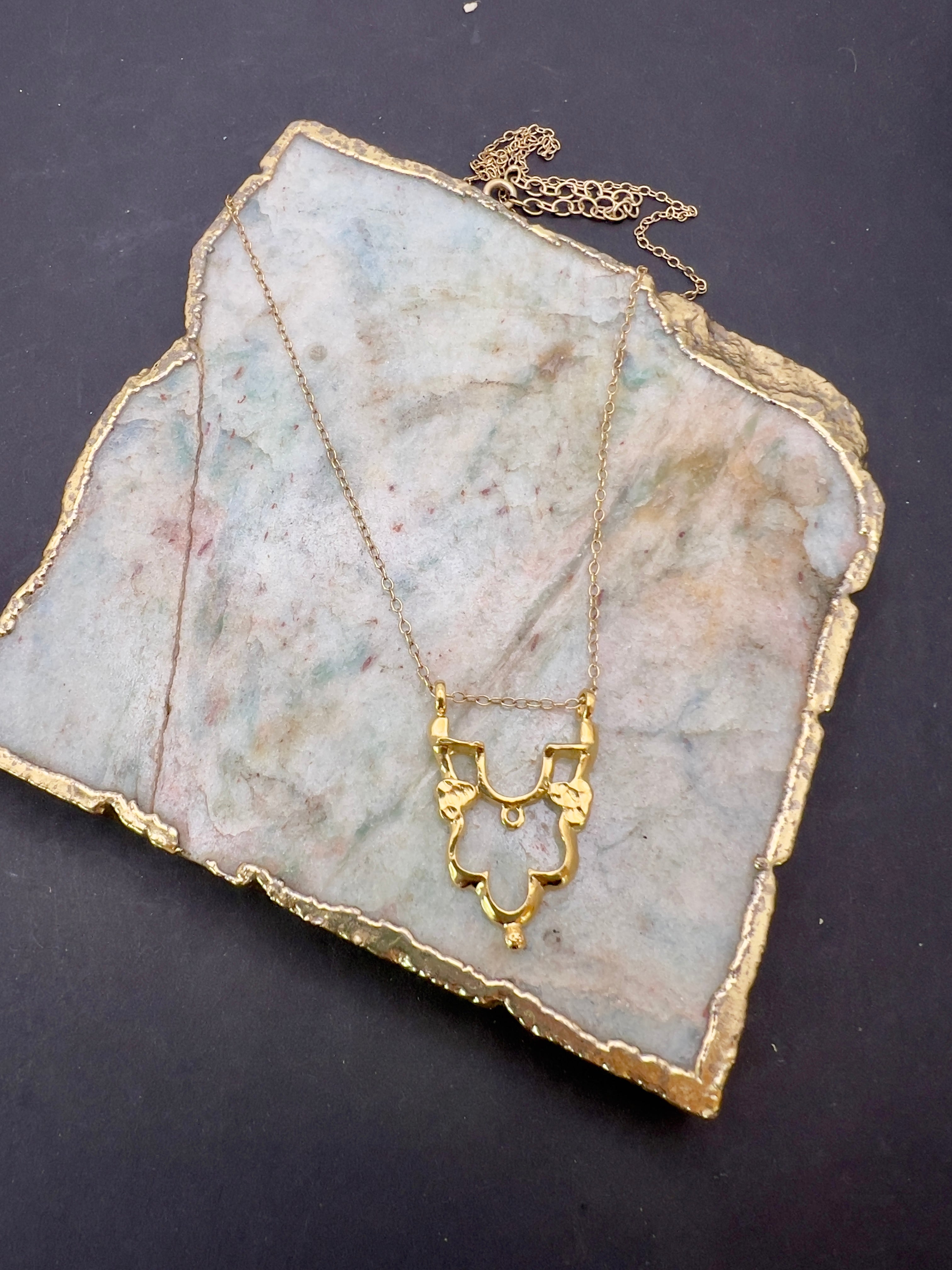 Gold Shikara half pendant.