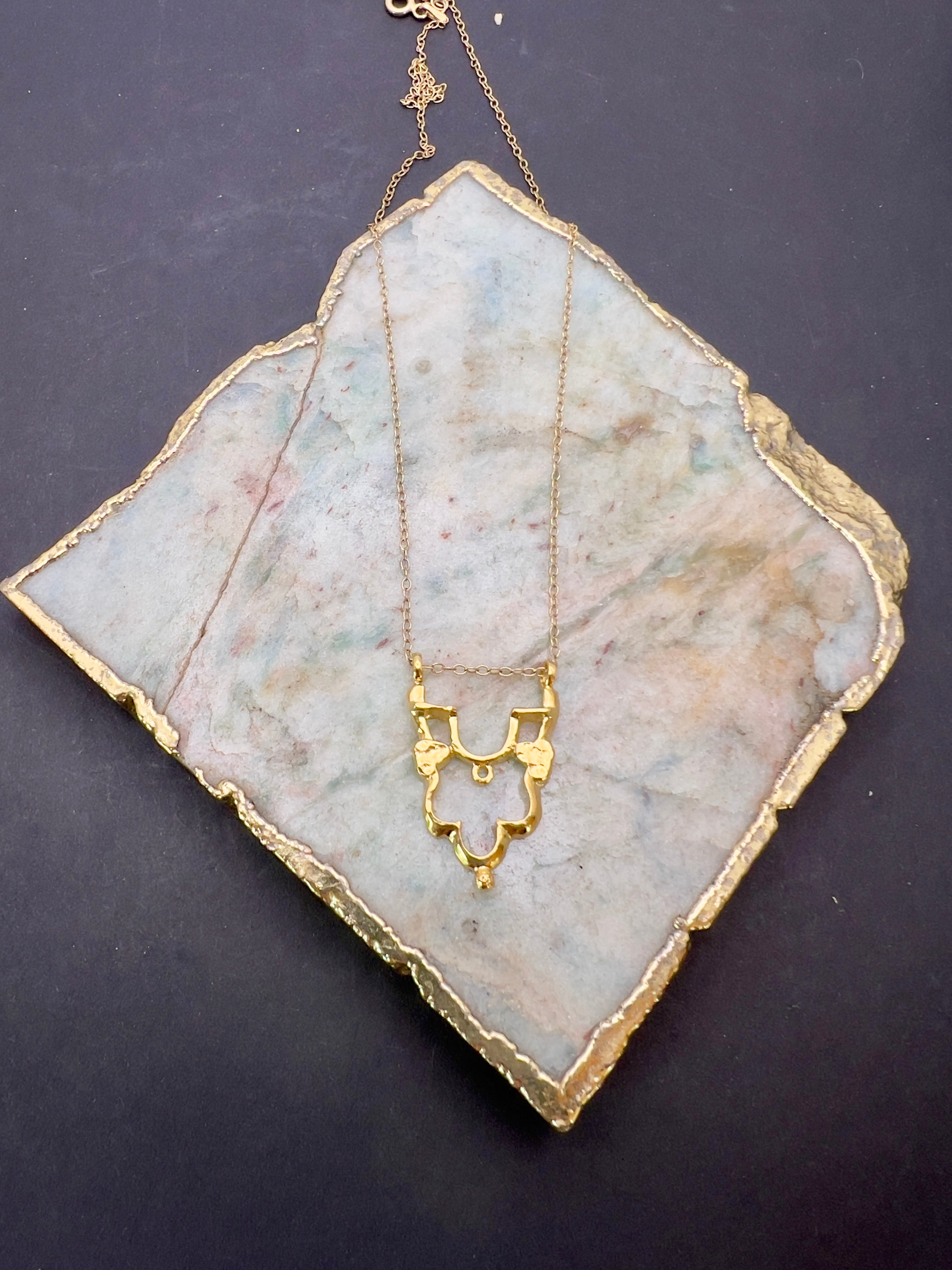 Gold Shikara half pendant.